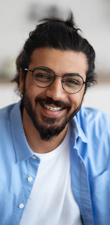 Man With Braces And Beard In Blue Button Up Shirt Smiling